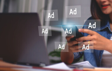 Digital marketing concept with businesswoman using computer laptop creating online adverts to increase sales. Using social media and websites for traffic and awareness, working in a modern office.