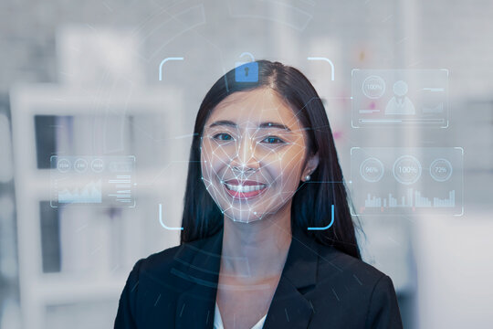 Asian businesswoman scanning  face ID to unlock security access with facial recognition technology for identification, with graphical technology illustration. Working in a company business.