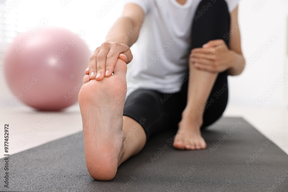 Sticker Woman suffering from foot pain at home, closeup