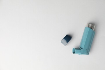 Asthma inhaler on light grey background, top view. Space for text