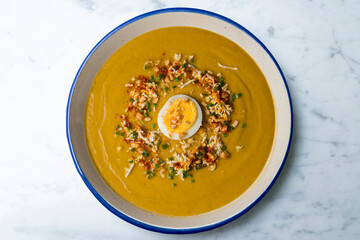 Cream of sweet potato and vegetables decorated with egg. Top view table with decorations.