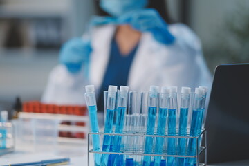 Group of dedicated scientist conduct chemical experiment in medical laboratory, carefully drop...