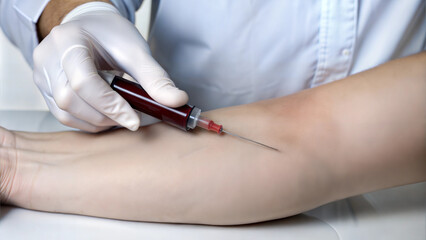 Nurse preparing to take a blood sample using syringe for medical testing and health check