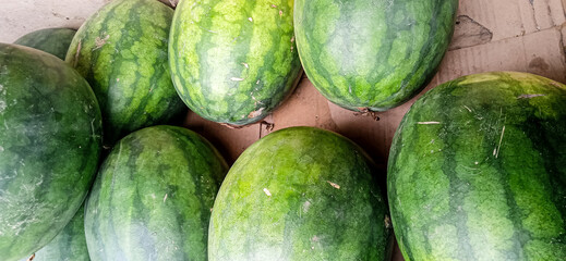 a collection of green watermelons in the fruit market
