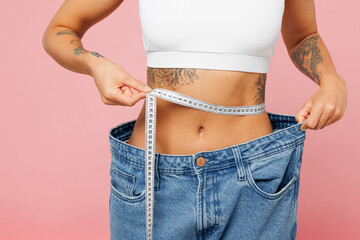 Close up cropped young woman wear white top casual clothes hold measuring tape on waist show loose...