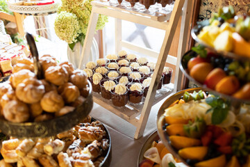 Banquet party cake table background. Sweet and delicious restaurant desserts. Rustic catering table. Bakery and pastry background. Cozy atmosphere wooden vintage food. Fine dining interior.