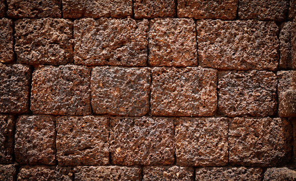 Ancient laterite brick wall for abstract seamless background and texture. beautiful patterns, space for work, close up.
