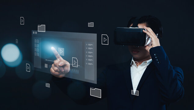 Businessman using VR virtual reality headset gear, working with multimedia software application technology, tools for business production, managing computer files document in augmented reality.
