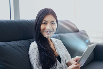 Asian businesswoman usingcomputer tablet scanning  face ID to unlock device security with facial recognition technology for identification, with graphical technology illustration.