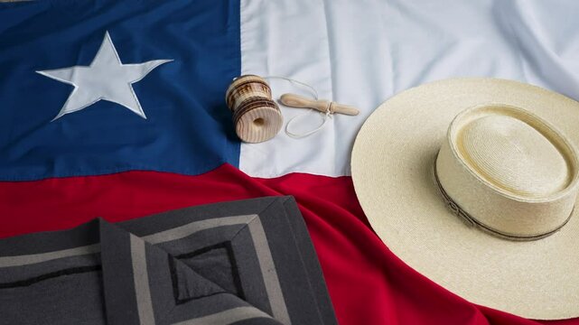 fondo chamanto de lana, chupalla y emboque sobre la bandera de Chile, celebraci&oacute;n fiestas patrias 