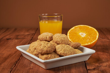 Homemade orange-flavored cookies accompanied by a glass of fresh orange juice