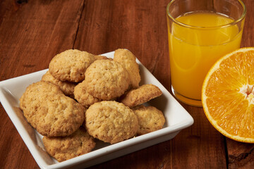 Homemade orange-flavored cookies accompanied by a glass of fresh orange juice