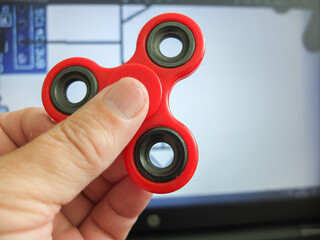 boy or man rotating fidget spinner in his hands