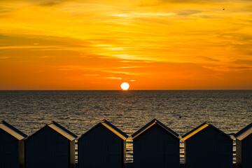 Coucher de soleil sur les cabine de plage et l'océan à Cayeux-sur-Mer