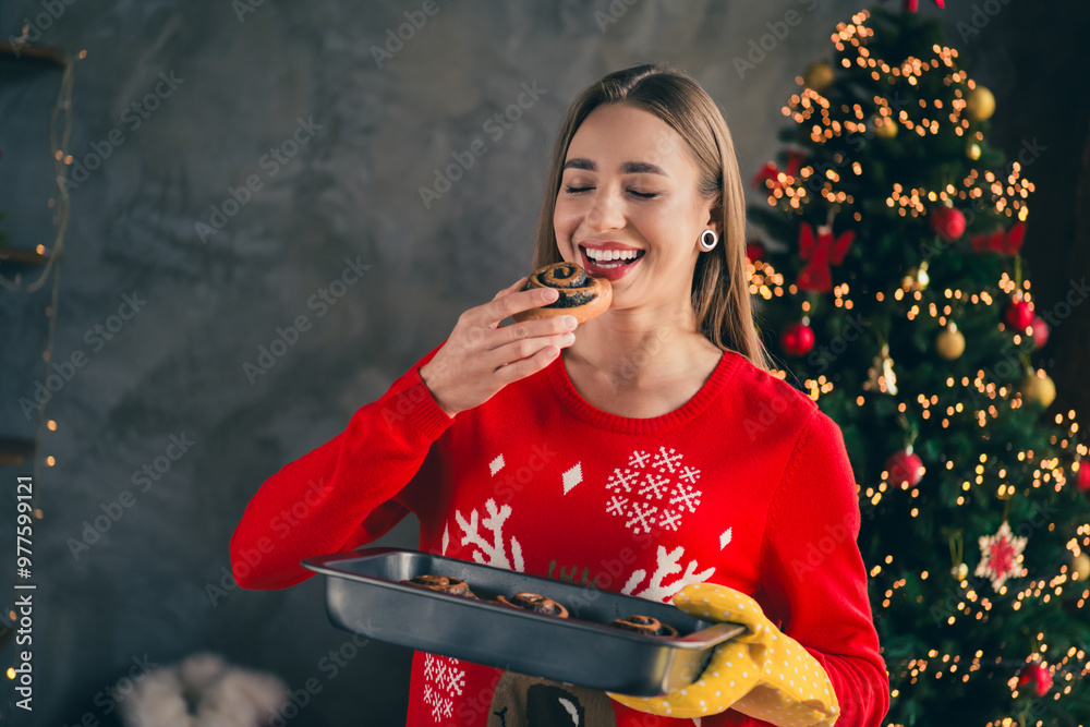 Canvas Prints Photo of lovely cheerful girl bake bun bite eating dressed red christmas garment tradition atmosphere decor vibe house indoors room