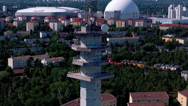 Aerial view showcasing a communication tower above Stockholm's urban landscape, highlighting landmarks such as the Ericsson Globe and Tele2 arena