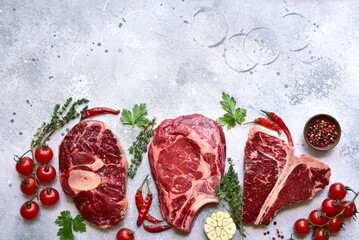 Different types of raw marbled beef steaks : T-bone, ossobuco, spider and rib eye with ingredients...