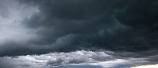 Obraz premium The dark sky with heavy clouds converging and a violent storm before the rain.Bad or moody weather sky and environment. carbon dioxide emissions, greenhouse effect, global warming, climate change