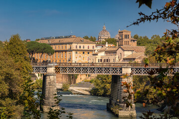 Naklejka premium Cityscape with old bridge on Tiber river and historic buildings on sunny day, Rome, Italy