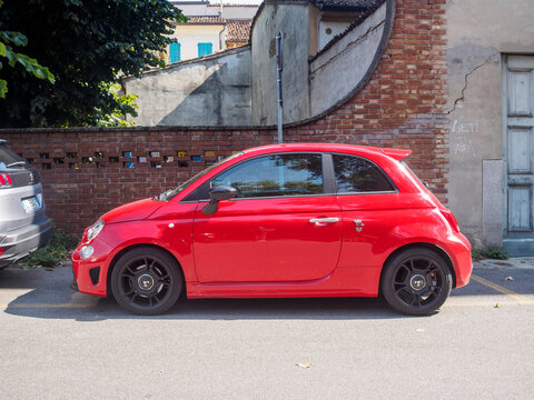 Red fiat 500 abarth parked on the street in summer