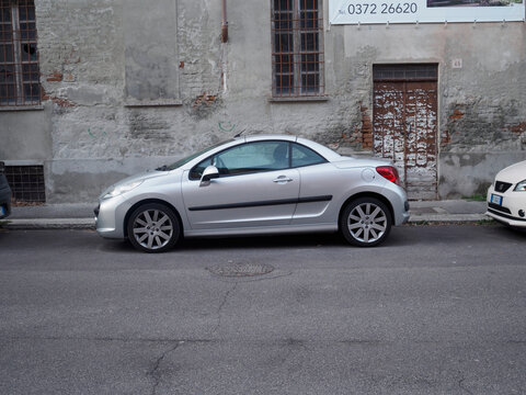 Silver peugeot 207 cc parked on a side street in italy