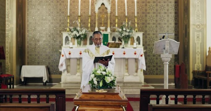 Funeral, bible and priest in church for religion, spiritual and worship sermon for mourning death. Memorial, prayer and senior male pastor read holy book and preaching for speech by coffin in chapel.