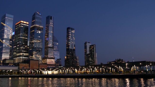 New York City skyline from river ferry boat. Manhattan Midtown, Hudson Yards skyscrapers from ferryboat. Waterfront panorama, riverfront buildings architecture, USA. Evening dusk, night twilight.