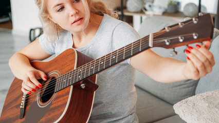 Tune instrument. Inspired woman. Favorite hobby. Female player adjusting sound of acoustic guitar...