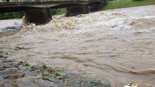 Swollen river. Power of water in flooded river bed. Floods in Czech republic.