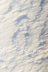 texture of snow lying in layers on a flat surface in sunny weather