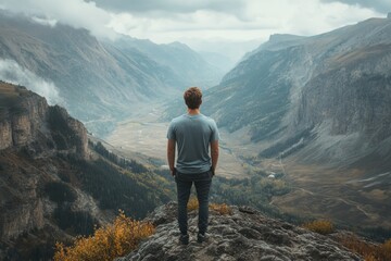 Naklejka premium Exploring Nature - Hiker Stands On Top of Mountain looking out 