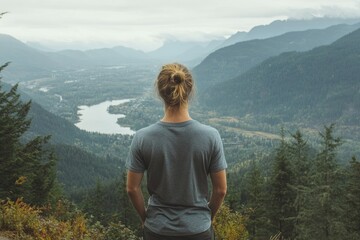 Naklejka premium Exploring Nature - Hiker Stands On Top of Mountain looking out 
