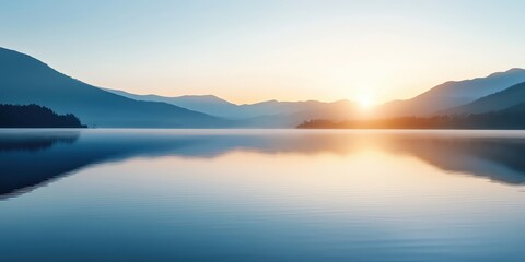 Fototapeta premium Sunrise over a calm lake with mountain reflections.