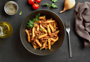 Penne pasta with minced meat, tomato sauce and greens