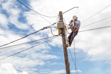 electrician removes an old lamp from a pole to install a newer one
