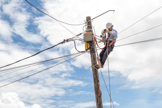 electrician removes an old lamp from a pole to install a newer one