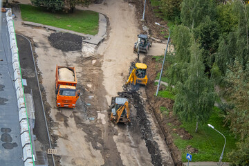 Road works are underway. Powerful equipment is at work: excavators, a truck, a bulldozer