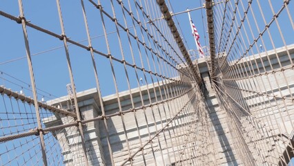 Brooklyn Bridge to Manhattan downtown, cables and blue sky. New York City symbol, USA travel destination. Architecture of United States of America, tourist landmark. Cable-stayed bridge. Dutch angle.