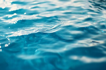 Close up of rippling blue water surface with sunlight reflection. Abstract background texture of liquid.
