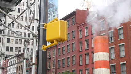 Steam vapor vented, New York City Water street, orange vapour tube stack. Hot smoke from pipe. Con...