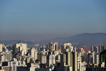 Obraz premium A thick layer of air pollution is seen covering the city of Sao Paulo, Brazil. Pico do Jaragua mountain is seen in the background right.