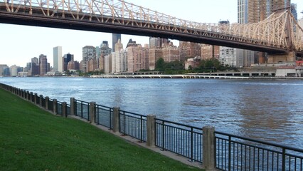 New York City waterfront skyline, Queensboro Bridge, Manhattan Midtown buildings, riverfront skyscrapers. Waterside cityscape view from Roosevelt Island. United States architecture and real estate.