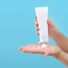 Hand pouring lotion or cream on hand, isolated background 