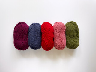 Colorful woolen yarn on a white background. Supplies for knitting, crafts, and hobby. 