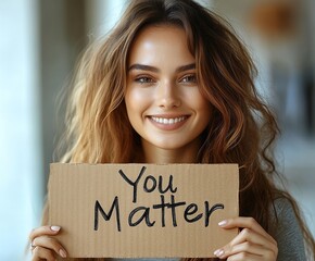 Smiling woman holds sign saying You Matter, spreading positive message.