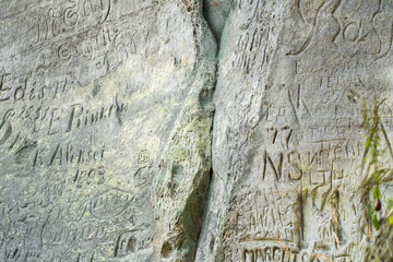 Obraz premium Carvings and Graffiti Etched Into Weathered Rock