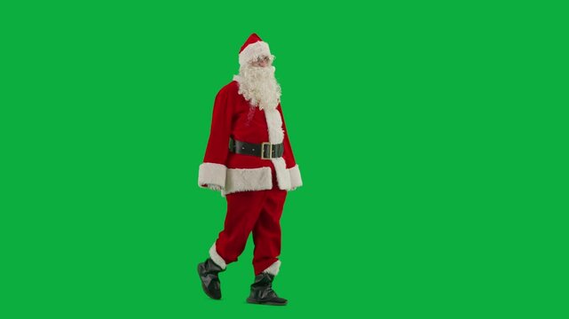 Portrait of man dressed as Santa on chroma key green screen background. Santa Claus in red outfit with beard and mustache walking looking around. Half turn.