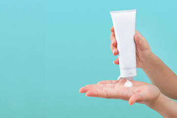 Hand pouring lotion or cream on hand, isolated background 
