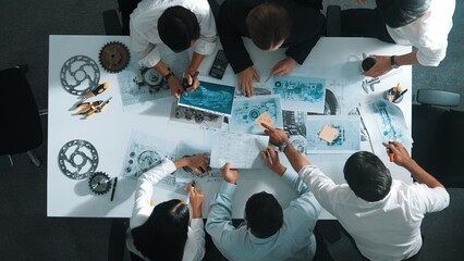 Top down aerial view of smart engineer team working together to design turbine engine. Professional...