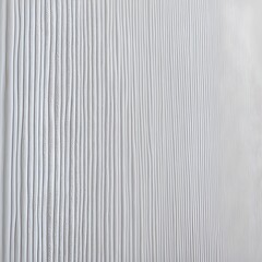 close-up view of a textured surface with a repetitive pattern. The surface is white and features horizontal rows of small, evenly spaced vertical ridges.